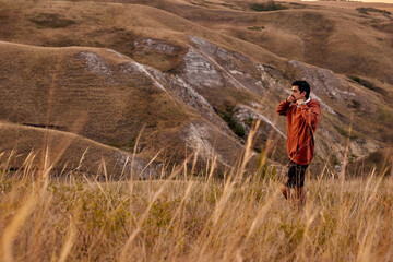 Naklejka premium Athlete man running sport. Runner have rest after jogging outdoors with beautiful landscape around. In nature. Male with headphones enjoy the view scene surrounding him, in contemplation