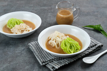 Kue Putu Mayang is traditional Indonesian snack made from rice flour strands curled up into a ball, served with coconut milk and palm sugar. Selected focus.
