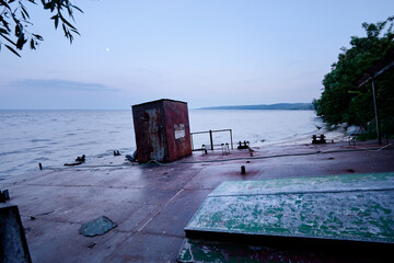 An old shipwreck boat abandoned stand on river sand beach.