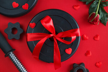 Ribbon wrapped dumbbells barbell weight plates and roses as a love gift for Valentine's Day,...