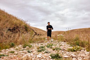 Never stop. Sportsman in black sportswear running in nature. Morning cardio. Caucasian bearded man jogging outdoors. Sport. Workout. Healthy active lifestyle, people exercising. Fitness concept