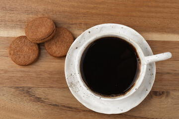 white coffee Cup on wooden background with grey linen tablecloth in jacquard weave, space for text