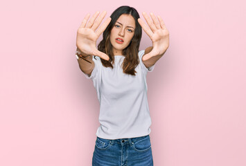 Young beautiful woman wearing casual white t shirt doing frame using hands palms and fingers, camera perspective