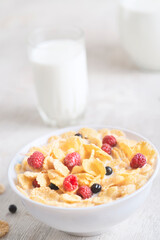 Healthy breakfast with cereal and blueberry and raspberry.Bowl with healthy cornflakes, milk and berries on white table.Tasty circle cornflakes.oatmeal with fruits. Diet concept.