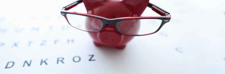 Red pig in glasses stands on ophthalmological table closeup - obrazy, fototapety, plakaty