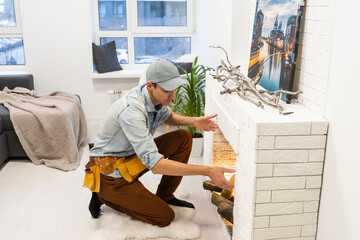 Service technician repairing a fireplace in a home