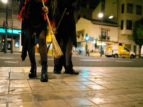 the legs of two young women dressed as witches for Halloween on the streets of Valencia, Spain.