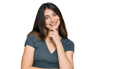 Fototapeta premium Young beautiful teen girl wearing casual crop top t shirt looking confident at the camera smiling with crossed arms and hand raised on chin. thinking positive.