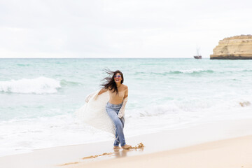 Fototapeta na wymiar young beautiful girl having fun on the beach in Portugal against the backdrop of the Atlantic Ocean