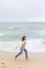 young beautiful girl having fun on the beach in Portugal against the backdrop of the Atlantic Ocean