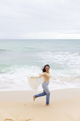 Fototapeta na wymiar young beautiful girl having fun on the beach in Portugal against the backdrop of the Atlantic Ocean