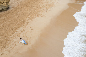 top view of a young beautiful girl relaxing on the beach in Portugal