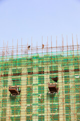 construction workers build scaffolding at a construction site in North China