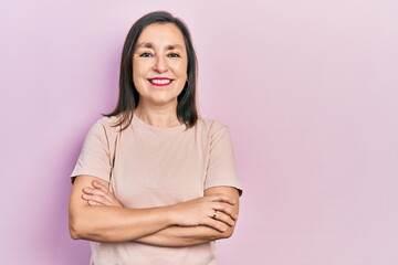 Middle age hispanic woman with arms crossed gesture smiling with a happy and cool smile on face. showing teeth.