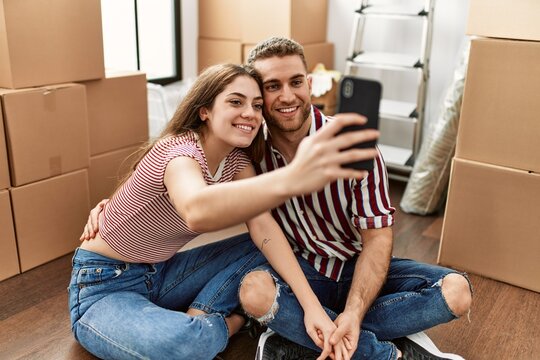 Young caucasian couple smiling happy make selfie by the smartphone at new home.