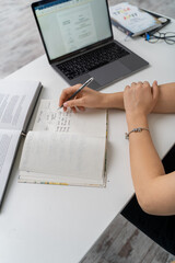 Woman writes on a book in the office.