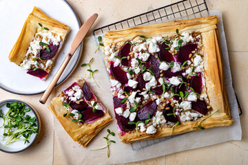 Beetroot and feta filo pizza. Beet Tart with feta, caramelized onion, pine nuts, sunflower micro greens and phyllo dough. Savoury vegetable vegetarian baking.