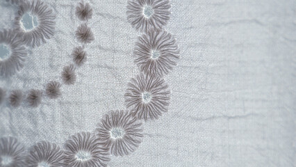 White floral embroidery on white colored fabric for dress, detail embroidery pattern, selective focus