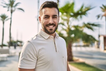 Fototapeta premium Young hispanic man smiling confident walking at street
