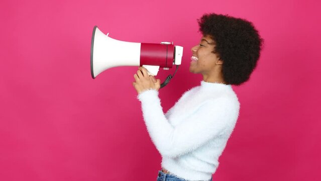 Young African American woman shouting through a megaphone over isolated background