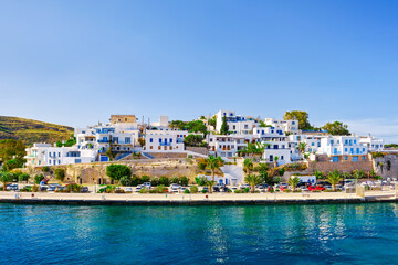 Fototapeta na wymiar Beautiful summer day, sunshine in typical marina of Greek island. Whitewashed houses by waterfront. Mediterranean vacations. Milos, Cyclades, Greece.