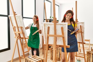 Mother and daughter listening to music and drawing at art studio