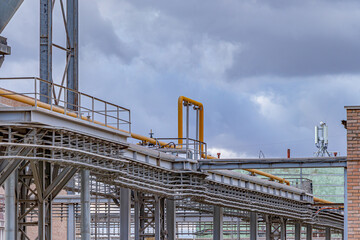 Technological structures of an industrial enterprise against the background of a bright sky and beautiful clouds