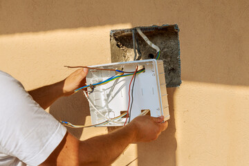 The electrician installs an electrical panel to connect the wires to the mains.