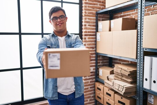 Down syndrome man ecommerce business worker holding package at office