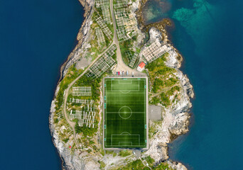 Aerial view of island with soccer field surrounded by blue sea, Henningsvaer, Lofoten, Norway © CA Irene Lorenz