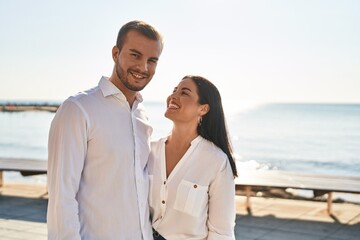 Obraz premium Man and woman couple smiling happy hugging each other standing at seaside