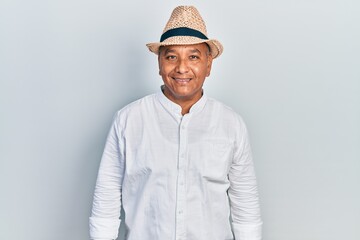 Middle age latin man wearing casual clothes and hat looking positive and happy standing and smiling with a confident smile showing teeth