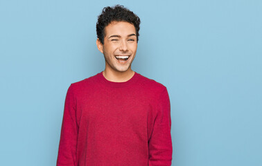 Young handsome man wearing casual clothes winking looking at the camera with sexy expression,...