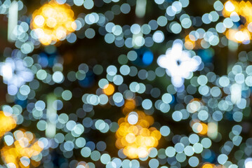 blurred lights in the background. Multicolored bokeh creating a Christmas atmosphere. Blurred christmas tree decorated with christmas lights.