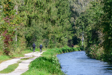 Idyllische Naturlandschaft mit Radfahrern am Lochbach südlich von Augsburg 