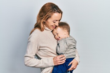 Young caucasian woman holding and hugging her son with love. Family of two bonding together. Mother holding infant toddler