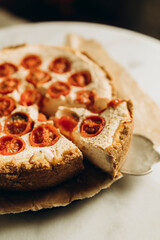 quiche with cherry tomatoes close-up. details of cottage cheese pie with tomatoes and spices. sliced pieces of homemade pie.	
