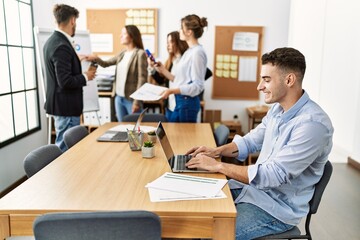 Young business worker smiling happy working while partners have break time at the office.