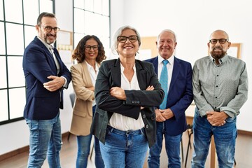 Fototapeta premium Group of middle age business workers smiling happy standing with arms crossed gesture at the office