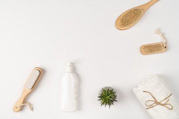 Flatlay, modern bathroom decor. Towels, wooden eco-friendly brushes and shampoo on a white background.