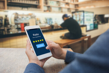 Rate your experience five star concept.Female hands holding mobile phone in coffee shop