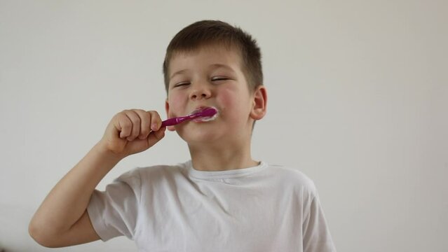 kid boy brushing his teeth using tooth brush and oral paste, cleaning teeth. 