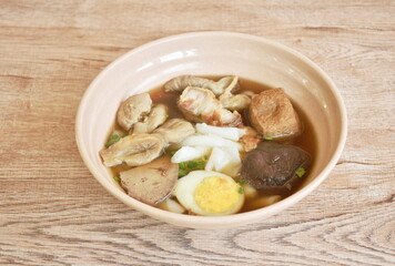 Chinese rice flour paste with pork and entrails topping creamy egg yolk in soup on bowl