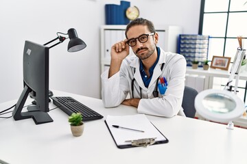 Handsome hispanic man working as doctor at hospital clinic