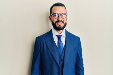 Young man with beard wearing business suit and tie with a happy and cool smile on face. lucky person.