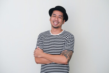 Tattooed Asian man smiling happy with arms crossed