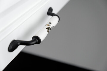 Extremely close-up detail of vintage white cabinet, original ceramic handles, selective focus, copy space