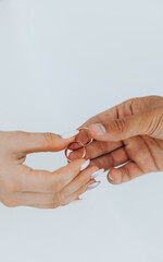 bride and groom together hold their golden wedding rings.