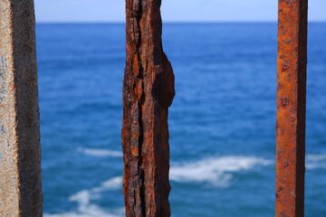 Rust metal barr with blue sea behind