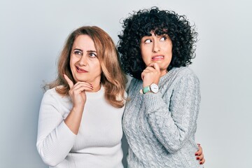 Middle east mother and daughter wearing casual clothes thinking worried about a question, concerned and nervous with hand on chin